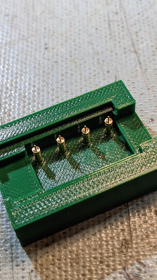 Custom-designed fixture holding pogo pins in perfect alignment for soldering