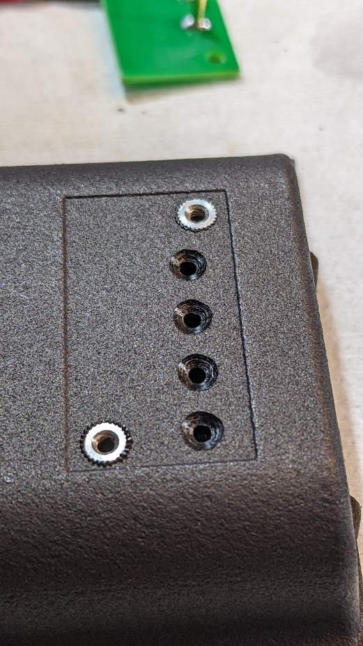 Close-up of battery tray heat-stake inserts and board attachment